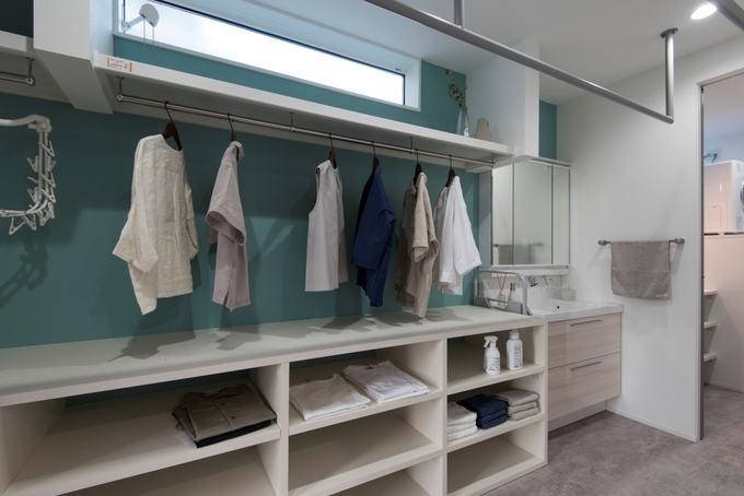 大容量の収納棚を造作した広い洗面室。ランドリー、浴室へと一直線につながり家事ラクを実現。「洗う・干す・しまう」が最短距離でこなせるため共働き・子育て夫婦の家事ストレスも軽減された