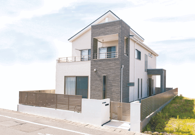 外観は白とグレーのツートンカラーに。玄関までのアプローチもゆったりとしている