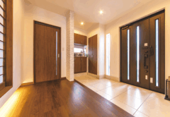 家の顔になる玄関も広々とした空間を希望。リビング同様、建具とフローリングにウォルナット色を用いて、家全体の統一感を持たせている。足元に採用したエンボス柄のタイルも印象的。