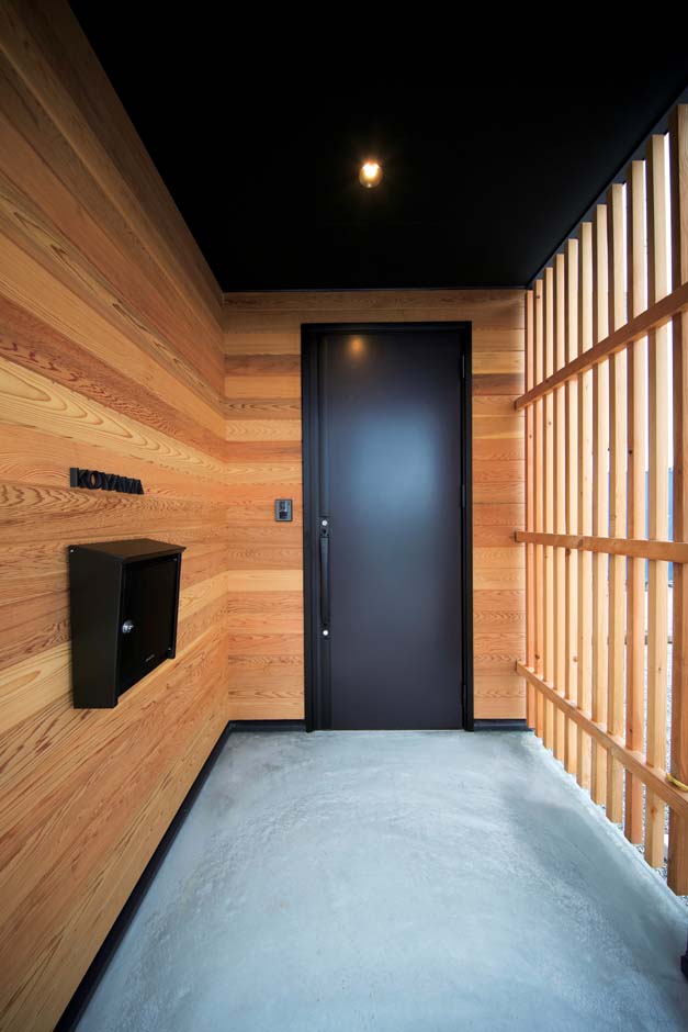 ARRCH アーチ【デザイン住宅、建築家、インテリア】板張りの外壁と格子戸に囲まれた玄関ポーチ。玄関ドアやポスト、天井は黒で統一