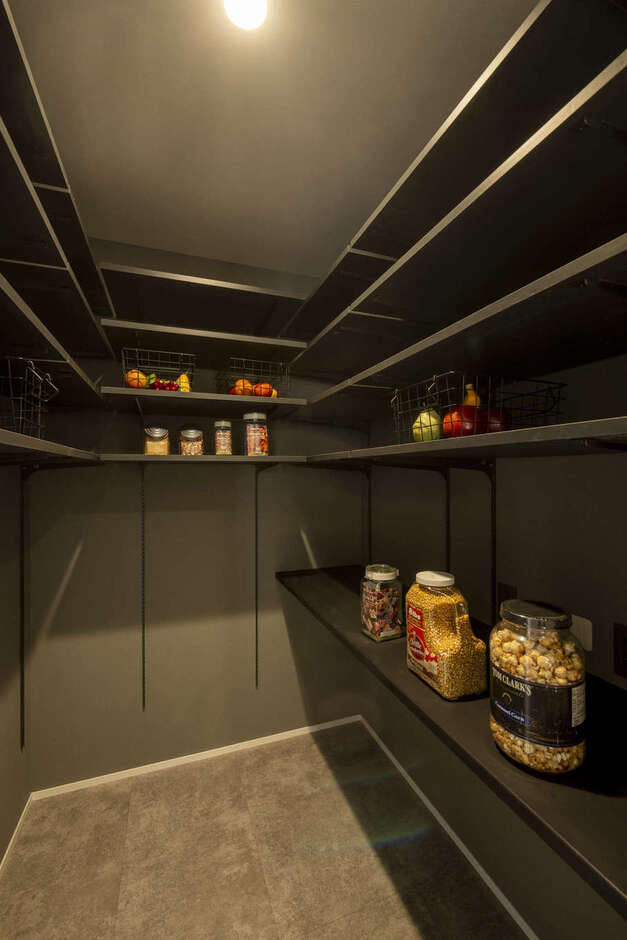 パントリーも「見せてもいい収納」を意識してグレーのクロスに黒い棚板を組み合わせ、デザイン性の高い空間に。コの字型に可動棚を設けてあり、収納力も抜群