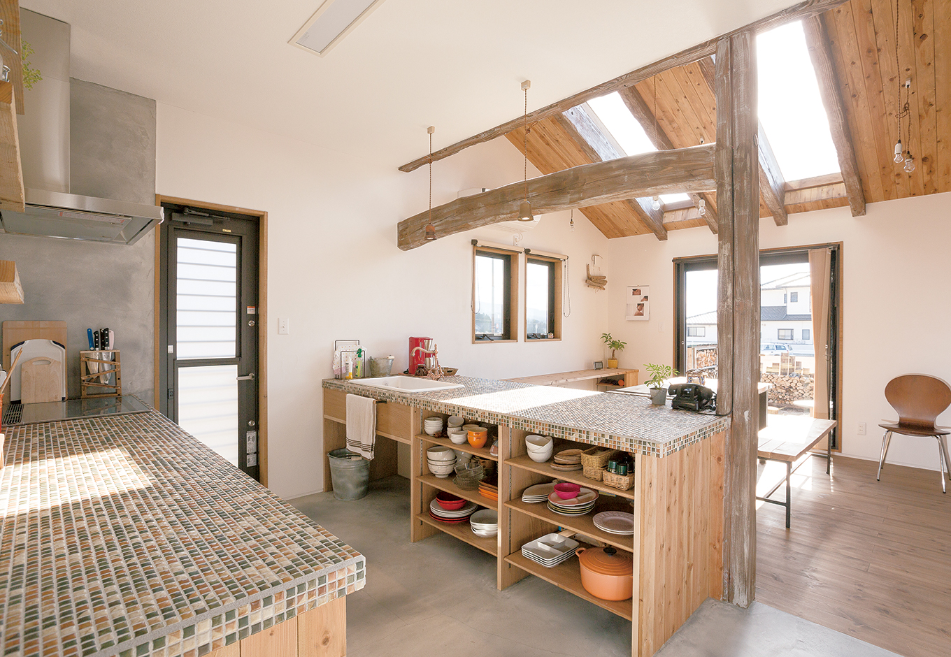 富士ホームズデザイン【デザイン住宅、子育て、インテリア】2枚の大きなトップライト（天窓）でダイニングはとびきり明るく暖かい。オリジナルキッチンはシンクとガス台を分け、間のスペースを広くした。お菓子作りが得意な奥さまは「素敵なキッチンで料理が楽しくなった」と嬉しそう