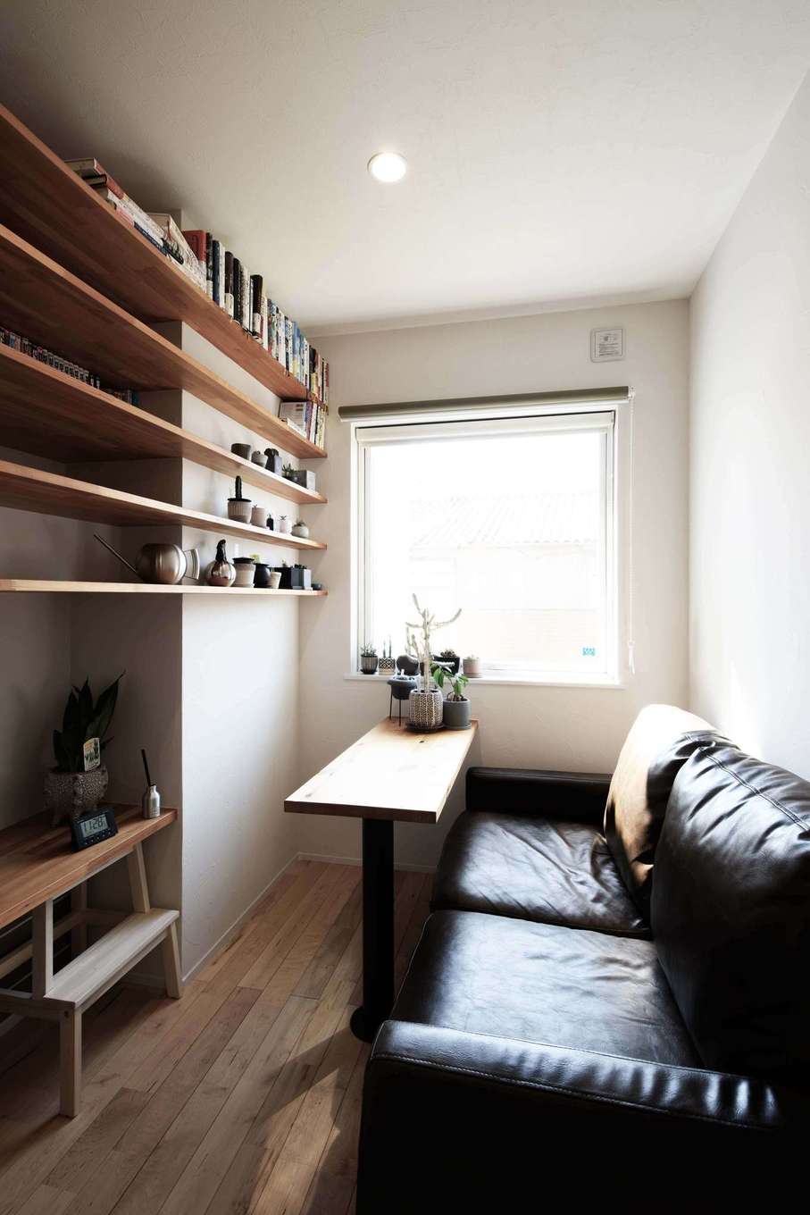 平屋建築ブルーハウス【デザイン住宅、子育て、平屋】リビングの隣に設けたご主人の書斎は、自分時間を心置きなく楽しむ空間。ソファのサイズに合わせてテーブルを造作しており、使い勝手が抜群。壁面には収納棚をたっぷり設けている
