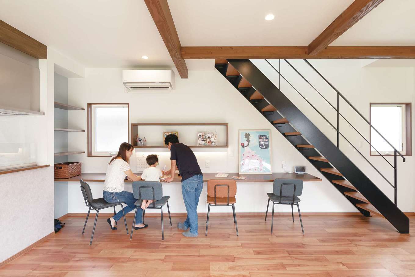 ホームプラザ大東【デザイン住宅、子育て、収納力】「子どもが大きくなっても自然に顔を合わせるようにしたい」というご主人の希望で階段はリビングインスタイルに。宿題だけでなく、パソコンや仕事にも使えるよう、カウンターは長めにしてもらった。教科書などを置ける棚の下の壁は、マグネットがつくようになっている