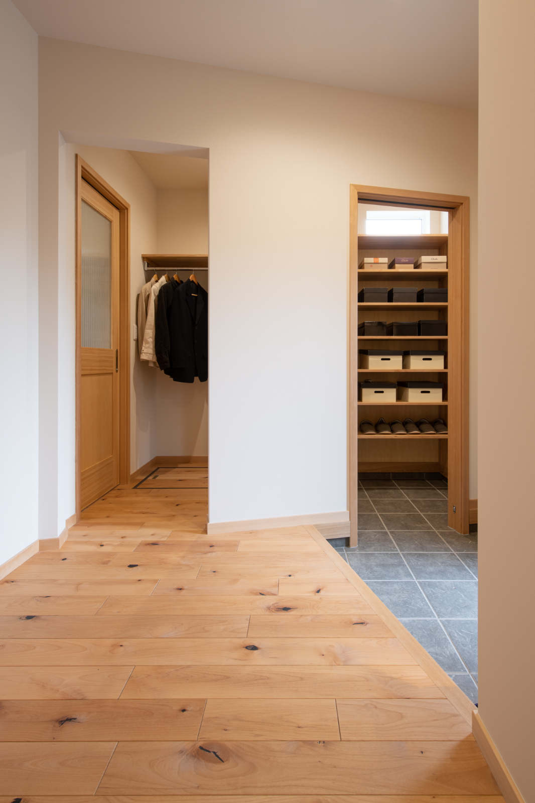 Sus∞Eco Home（サスエコホーム）｜玄関からすぐのシューズクローク。コートや靴をまとめて収納できるスペースがあり、機能的で使いやすいデザイン。おしゃれな木製収納ボックスが印象的。