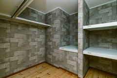 ２階の納戸にはしまうものに合わせて棚を設け、利便性を高めている。クロスに凝って、居室のようにスタイリッシュな空間に仕上げた