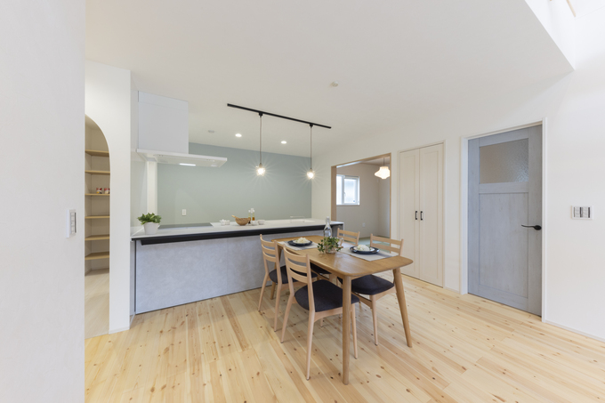 温かみのある木の床材が特徴的なダイニングスペース。明るい照明とシンプルなテーブルセッティングが心地良い雰囲気を演出。