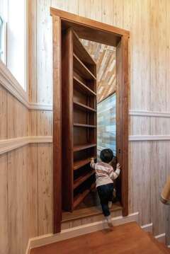 小屋裏に続く隠し扉。まるでファンタジー映画のよう。扉は本棚としても利用できる