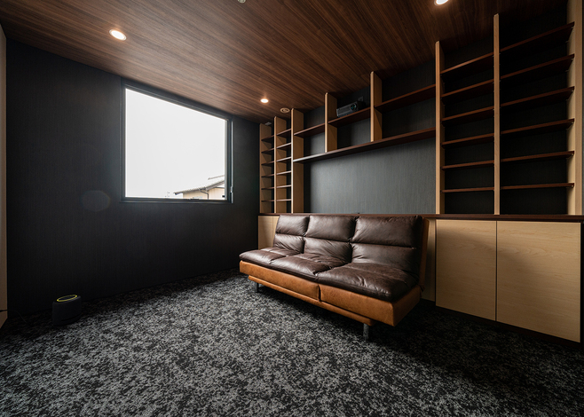 ご主人の夢を叶えたこだわりのシアタールーム。壁面の棚はDVDなどを収納できるよう、ご主人がオリジナルで製作した
