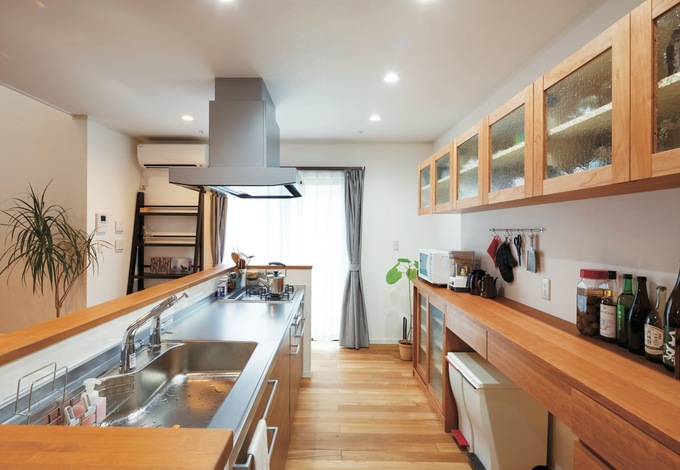 ブラックチェリーとアンティーク調のガラスを使った造作キッチンは、奥さまが基本設計した