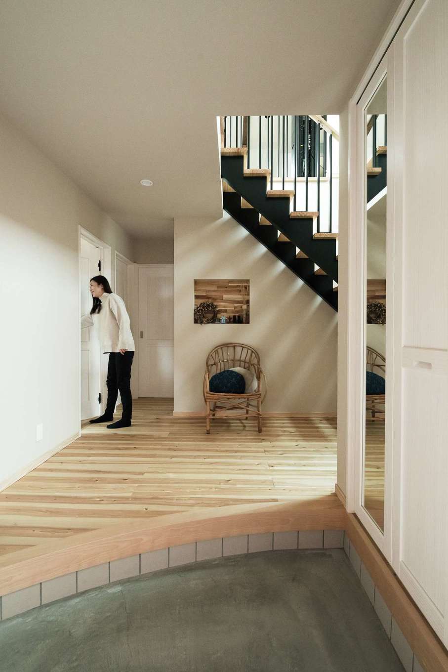 ワイズホーム【デザイン住宅、自然素材、省エネ】憧れていた広い玄関。上がりかまちは「直線にする意味はあるの?」というご主人の素朴な疑問からアールを付けた。吹き抜けの鉄骨階段と正面のニッチのバランスも絶妙