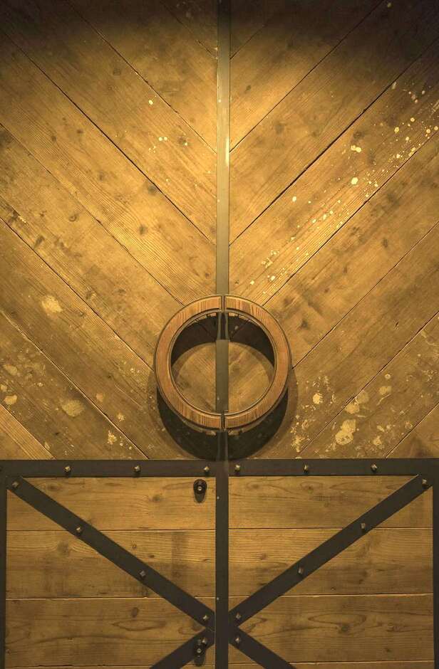 足場板で造作した玄関ドア。ラウンドの取っ手は木製。縁にアイアンをあしらう細かな細工が、デザインセンスや職人の技術の高さを物語る