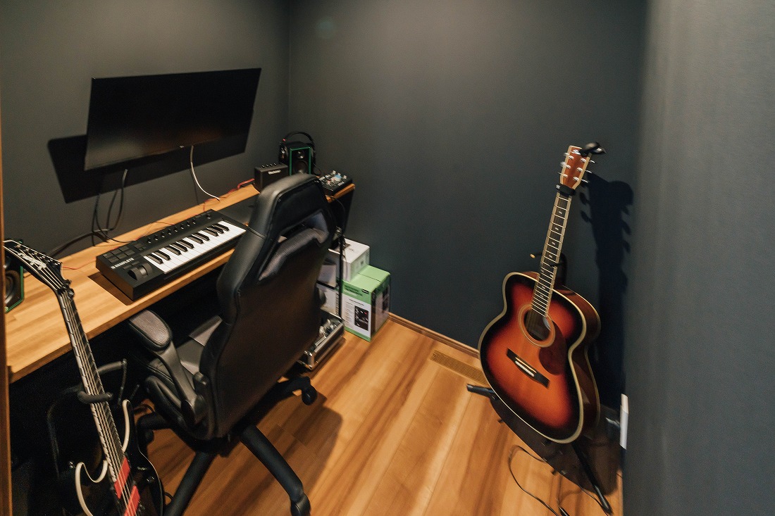 チェックハウス｜整然とした音楽ルーム。ギターやキーボードが配置され、音楽制作に最適な環境が整っている。