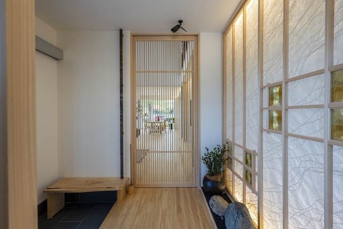 自然素材をふんだんに使った明るい玄関ホール。間接照明が優しい雰囲気を演出し、訪れる人を温かく迎える空間となっている。