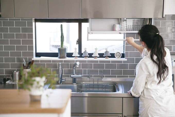 冷蔵庫を起点に、ステンレス製キッチン、反対側の盛り付け&収納カウンターまでを一直線で繋いだ。キッチン上部に食器乾燥棚があり、無駄がない