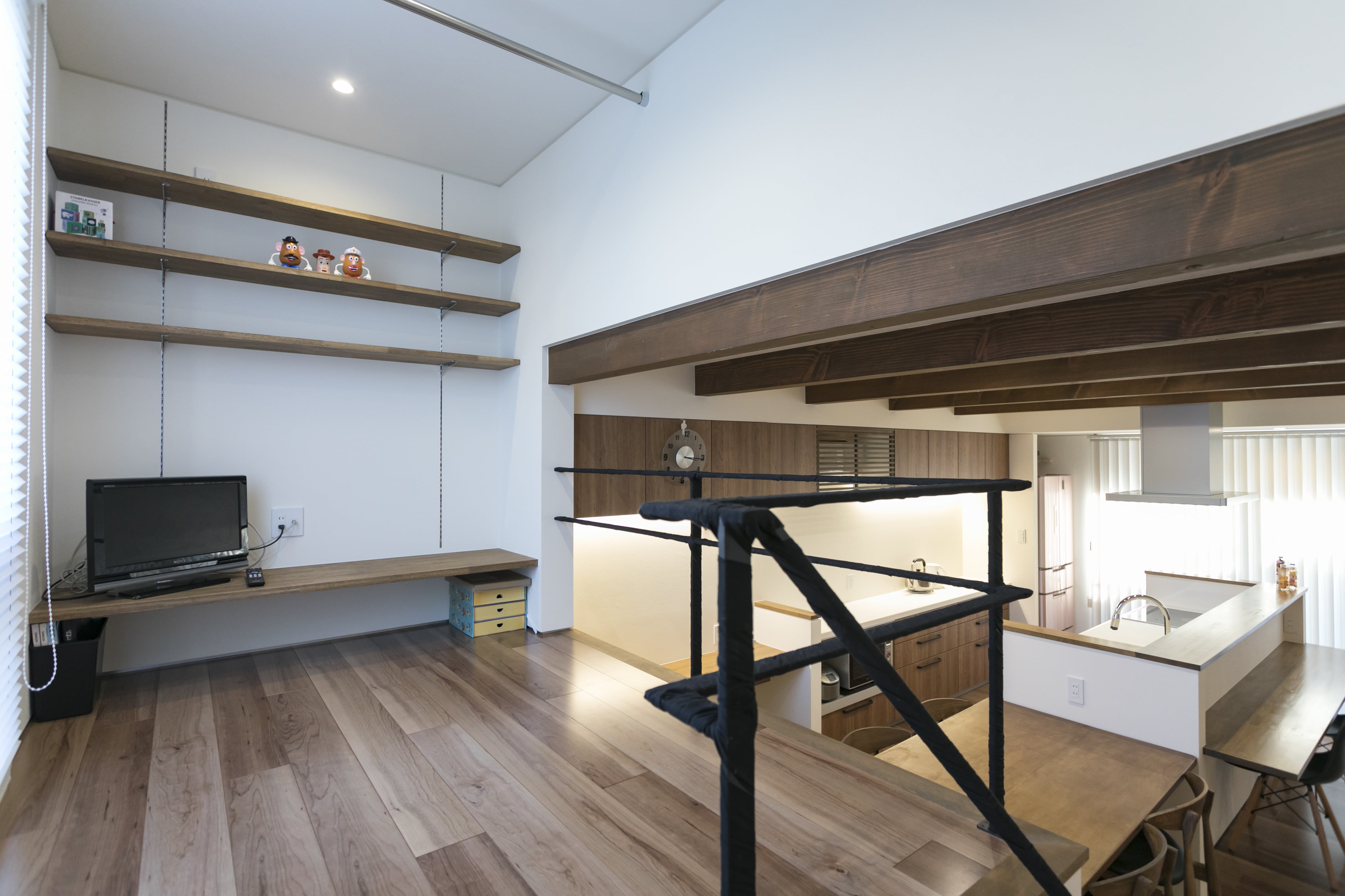 安田住宅｜安田建築設計室｜1.5層の書斎コーナー 兼 家事スペース。ナチュラルな木目の床と壁面の棚が調和し、ちょっとした作業やリラックスタイムに最適である。