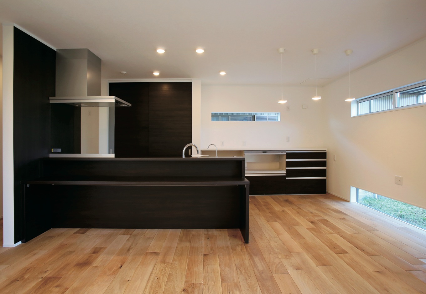 片桐建設【デザイン住宅、輸入住宅、省エネ】LDKは、白と木の空間に、キッチンはブラックで統一し、壁の上と下に横長の窓を配した