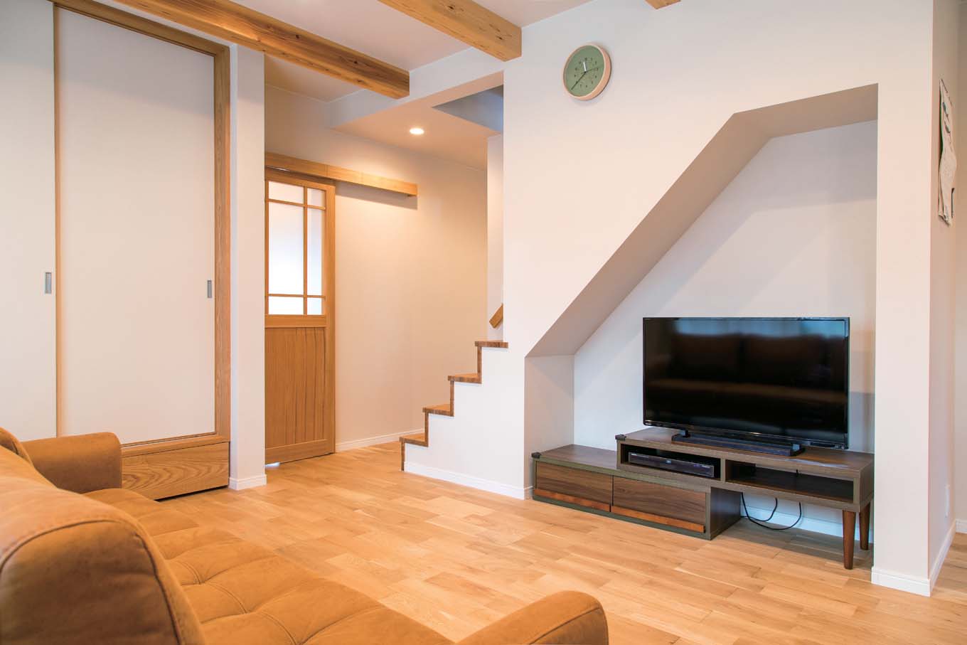 仲田工務店【デザイン住宅、子育て、間取り】階段下のニッチをテレビコーナーに活用。階段の壁は途中からとし、視線が奥まで抜ける。建具もすべて職人の手作り