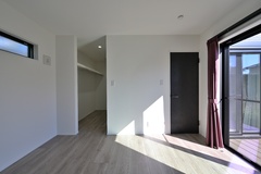 柔らかな光が差し込む寝室。奥には扉を設けないオープンタイプのウォークインクローゼットを配置し、使い勝手と開放感を両立させました。落ち着いたパープルのカーテンが、空間に上品な彩りを添えています。