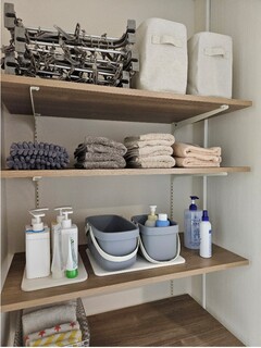 整然とした収納棚。タオルや洗剤を効率よく整理できるデザインで、空間を最大限に活用している。