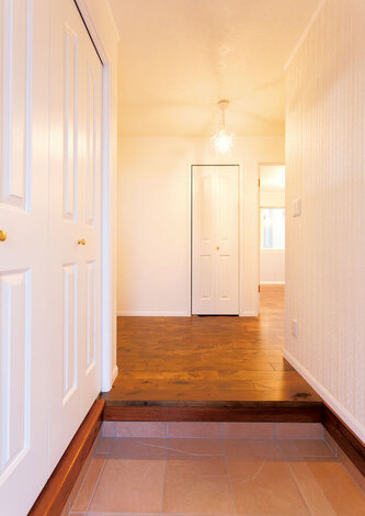 清々しい雰囲気の玄関。建具の白さと無垢材のフローリングのコントラストが美しい
