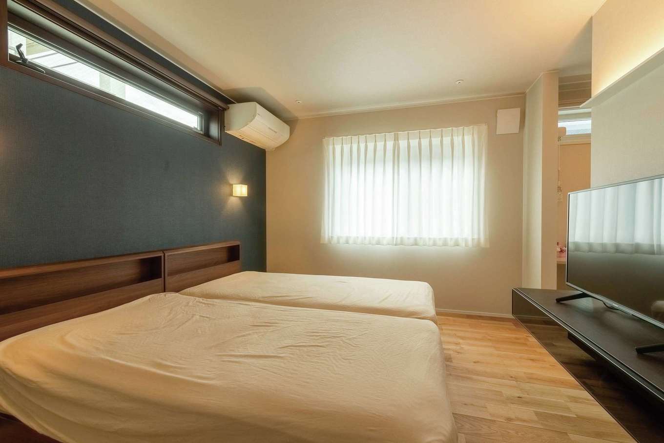 静鉄ホームズ【デザイン住宅、省エネ、インテリア】寝室はブルー系のクロスがアクセント。各居室に室内干し用のポールを備えているが、換気システムのおかげで臭いもなくすっきり乾くそう