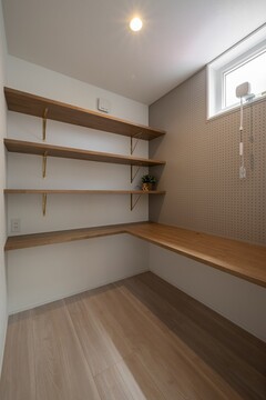 落ち着いたトーンのワークスペース。備え付けの棚とデスクが効率的な作業環境を提供している。