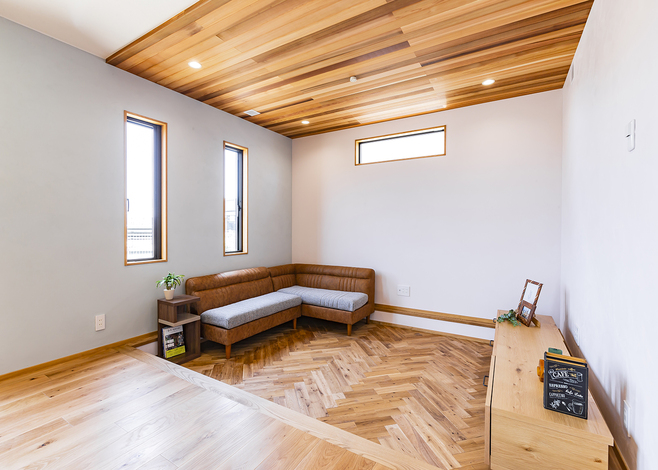 L字型ソファがおさまるピットリビング。ヘリンボーン張りが映える