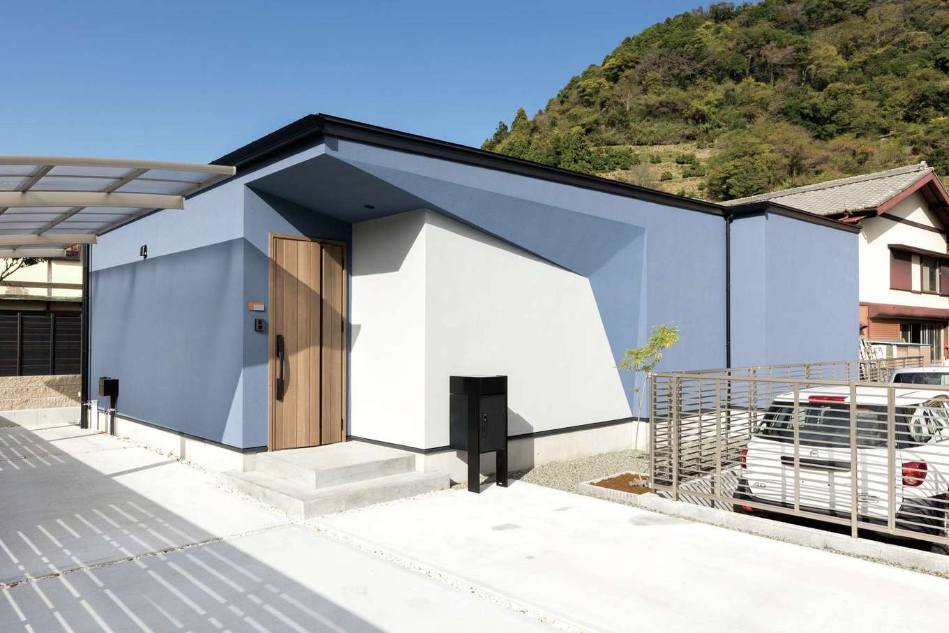ARCHITECT STUDIO TEGOKORO （遠藤建築店）【子育て、間取り、平屋】落ち着いたトーンのブルーと玄関のデザインが目を引くスタイリッシュな外観。こちらは「パティエ」シリーズの「ダイヤ」。東南側には窓を作らず外からの視線をカットした