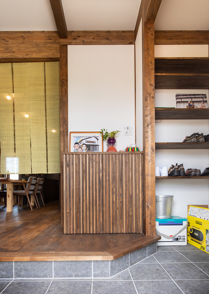 広々とした土間玄関。框を斜めに切ったことで、より広く感じられる。造作カウンターに写真やグリーンを飾って季節感を楽しむ