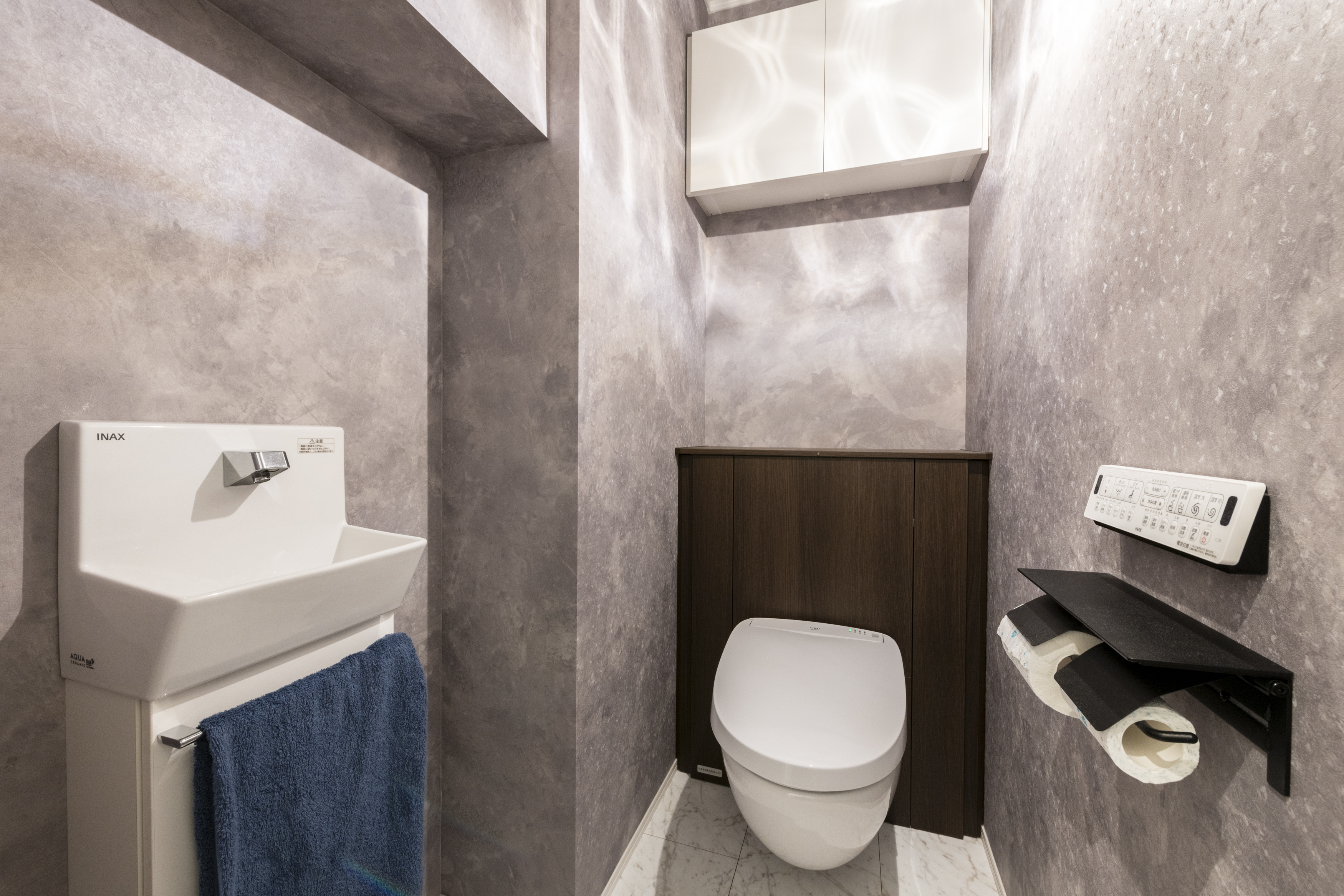 広島建設 セナリオハウス｜落ち着いたグレーの色調でまとめられたモダンなトイレ。グレーの色味にすることで、ペンダントライトの光の陰影がより際立ちます。