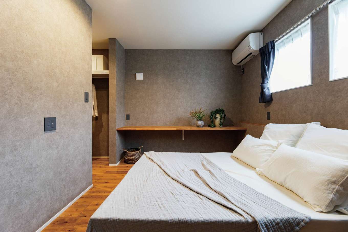 住家 JYUKA【デザイン住宅、間取り、平屋】無垢とグレーの色合いが、気持ちを落ち着かせてくれる主寝室。ワークスペースとしても使えるカウンターも用意した