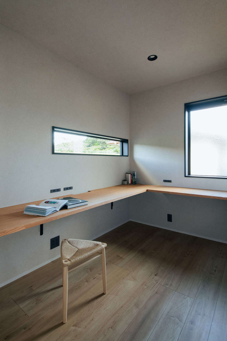 DAITOKU（大得工務店）【デザイン住宅、省エネ、間取り】ご主人専用の書斎。快適にリモートワークができるよう、造作カウンターの高さと形状、窓の位置と大きさにこだわった。作業しながらでもスリットの窓から青空と緑が半分ずつ見えるよう、施工前にシミュレーションをして設置