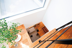 ダイニングの一部が吹き抜けに。開放感を演出するとともに玄関に明るさを届ける。たたきと同じタイルで作った式台がお洒落