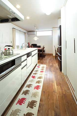 キッチン横にダイニングテーブルを並べるレイアウトが家事効率を高める。右手の収納はすべてを隠せるようになっていて、来客時に重宝