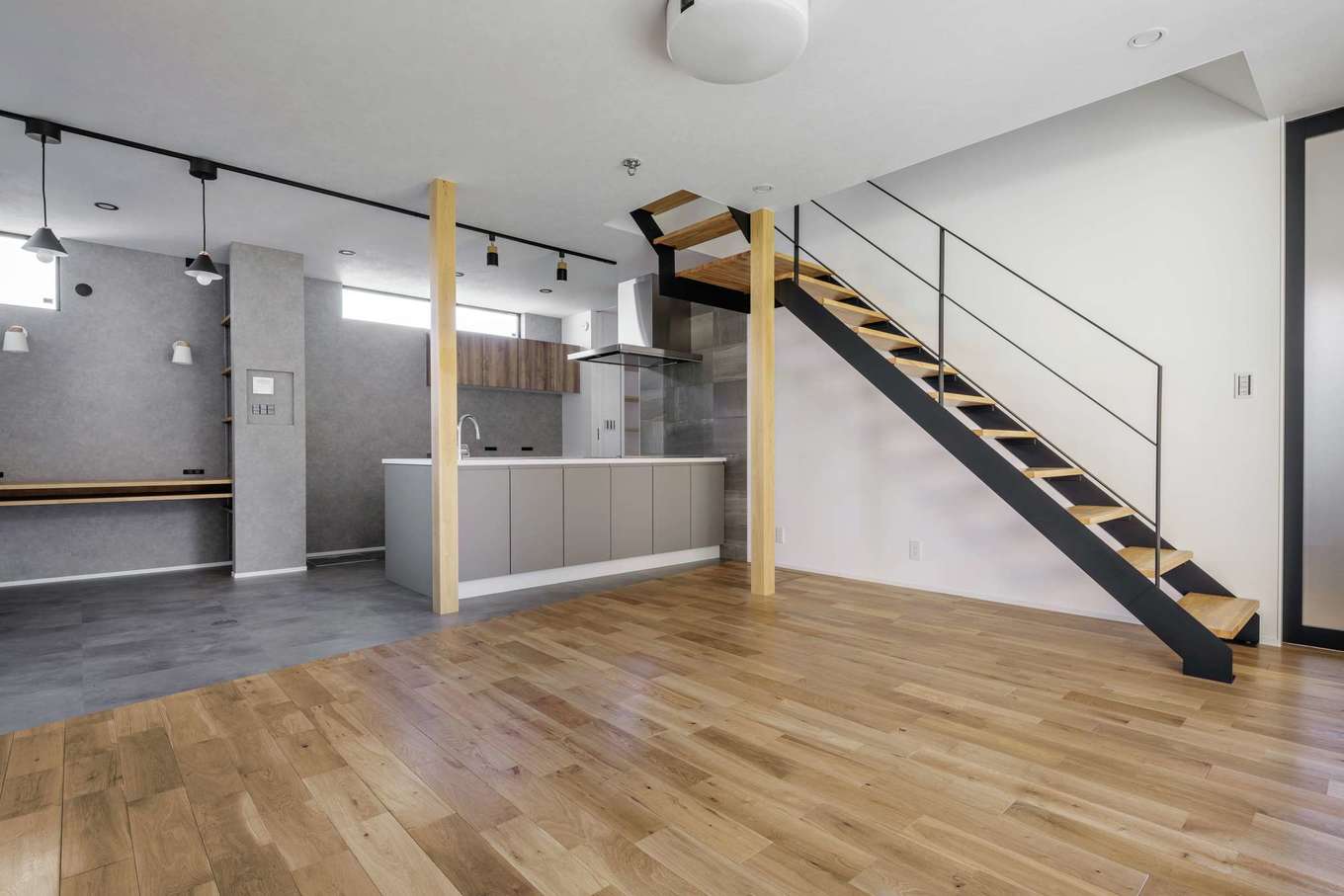 tact design firm【デザイン住宅、子育て、間取り】19.4畳のLDK。グレー、白、木目のシンプルな色合いでコーディネートした。コンパクトな空間でいかに広く過ごせるかを考えてプランニングした設計力が光る