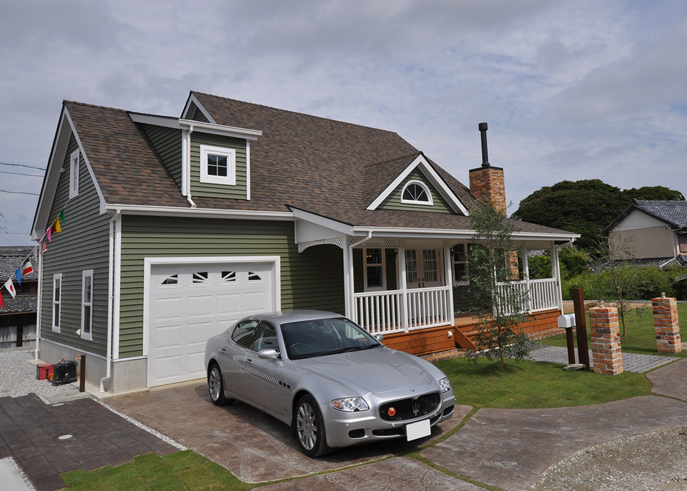 リンゾー【輸入住宅、ガレージ、デザイン住宅】ビルトインガレージ付きの外観。エクステリアも『リンゾー』がプランニングして、建物と庭とのバランスを確保した