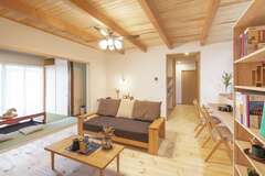 和モダン風の親世帯のLDK。キッチンの横に設けた書棚が冷蔵庫の目隠しになり、生活感を感じさせない美空間に。冬は蓄熱暖房器で節エネ＆小春日和の暖かさを実現