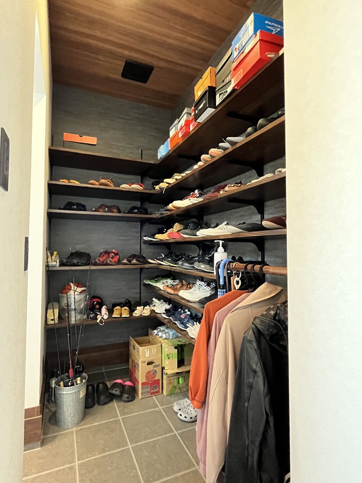 様々なアイテムを効率よく収納するためのシューズクローク。靴だけでなく、コートや小物も整理され、使い勝手の良さを感じる空間。