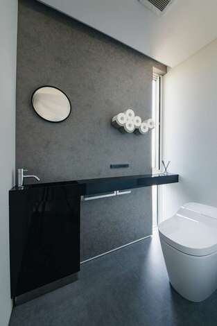 デザインと心地良さを両立したホテルライクなレストルーム。ペーパーホルダーや丸鏡のほか、光の取り入れ方や照明のあて方に建築家ならではのセンスが光る