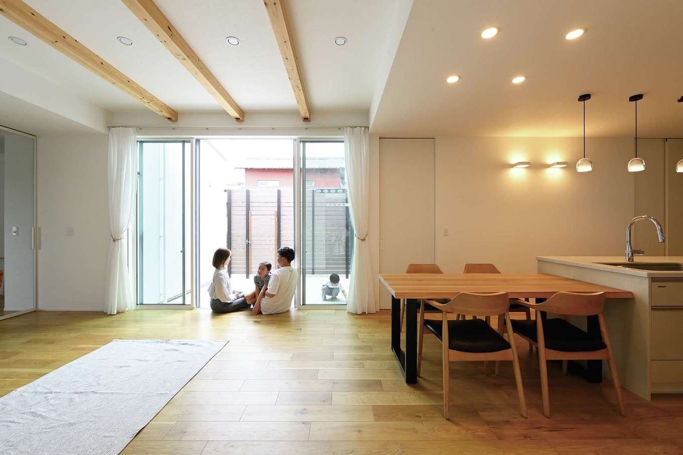 REIWA HOUSE（令和ハウス）【デザイン住宅、省エネ、間取り】リビングとシームレスにつながる中庭は、BBQやプールなど、視線を遮りながら楽しめるアウトドアリビングとして大活躍。ウッドフェンスを設けたことで、カーテンの要らない自由な暮らしを満喫している。ダウンライトはシーンに応じて調光可能