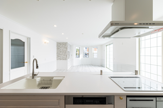 開放的な白を基調としたキッチン。洗練されたデザインと機能性が調和し、広々とした空間を演出している。