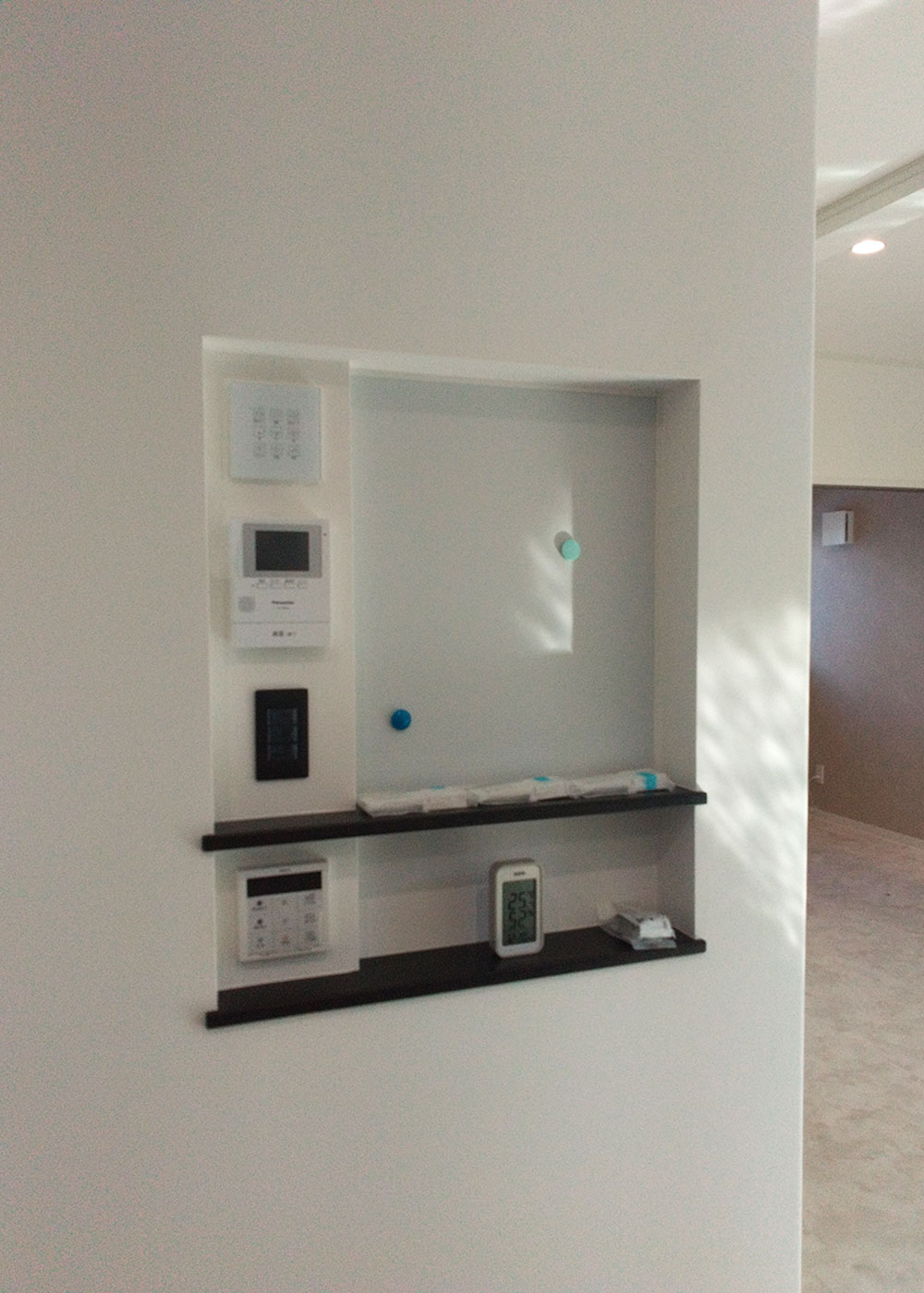 イシカワ【収納力、狭小住宅、インテリア】機器パネル用のニッチをつくり、それぞれの配置を現場で確認。中央のマグネットボードも便利