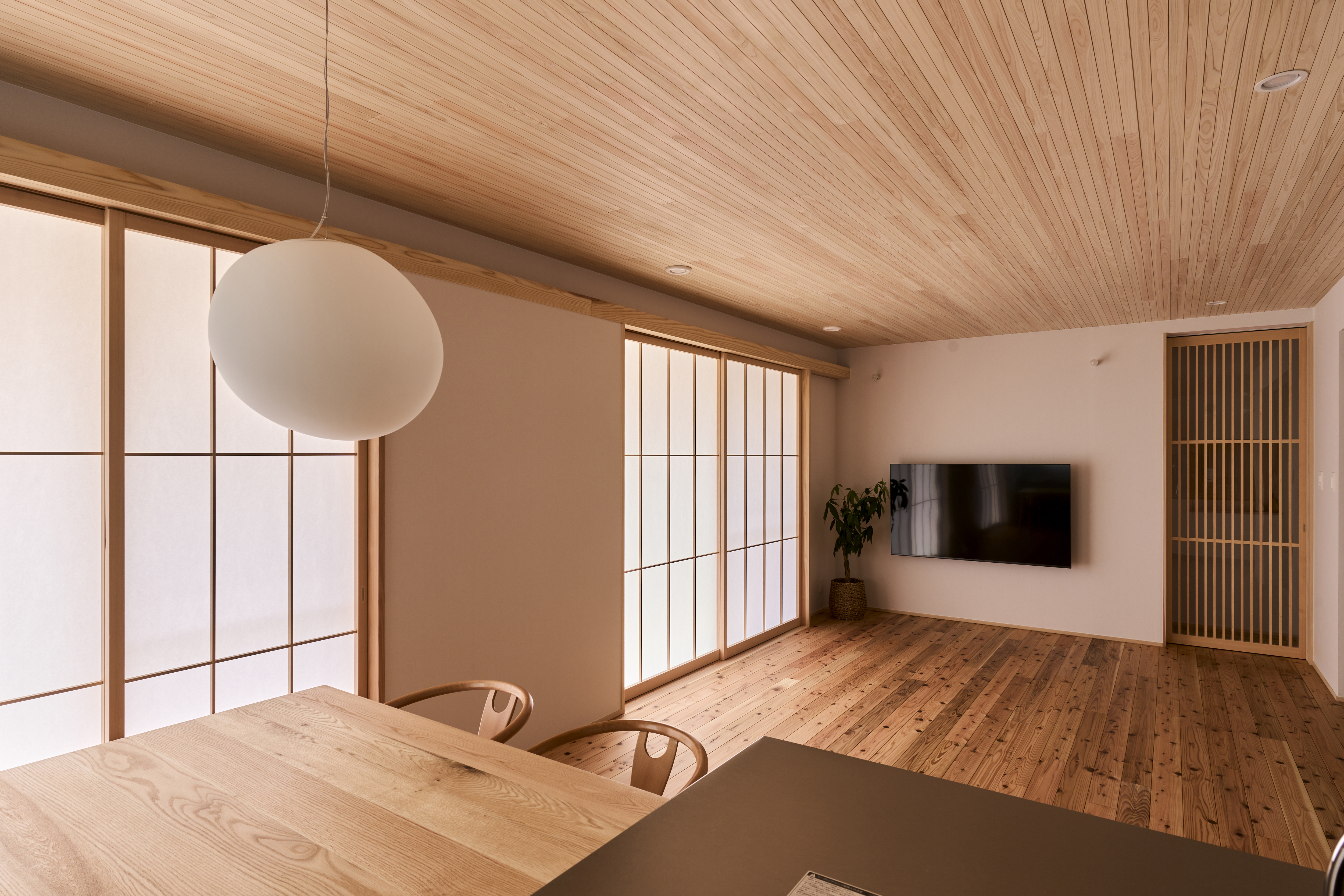 KEN建築工房｜和モダンなインテリアが特徴的なリビングダイニング。落ち着いた木目調の天井とフローリングが心地よい空間を演出しています。