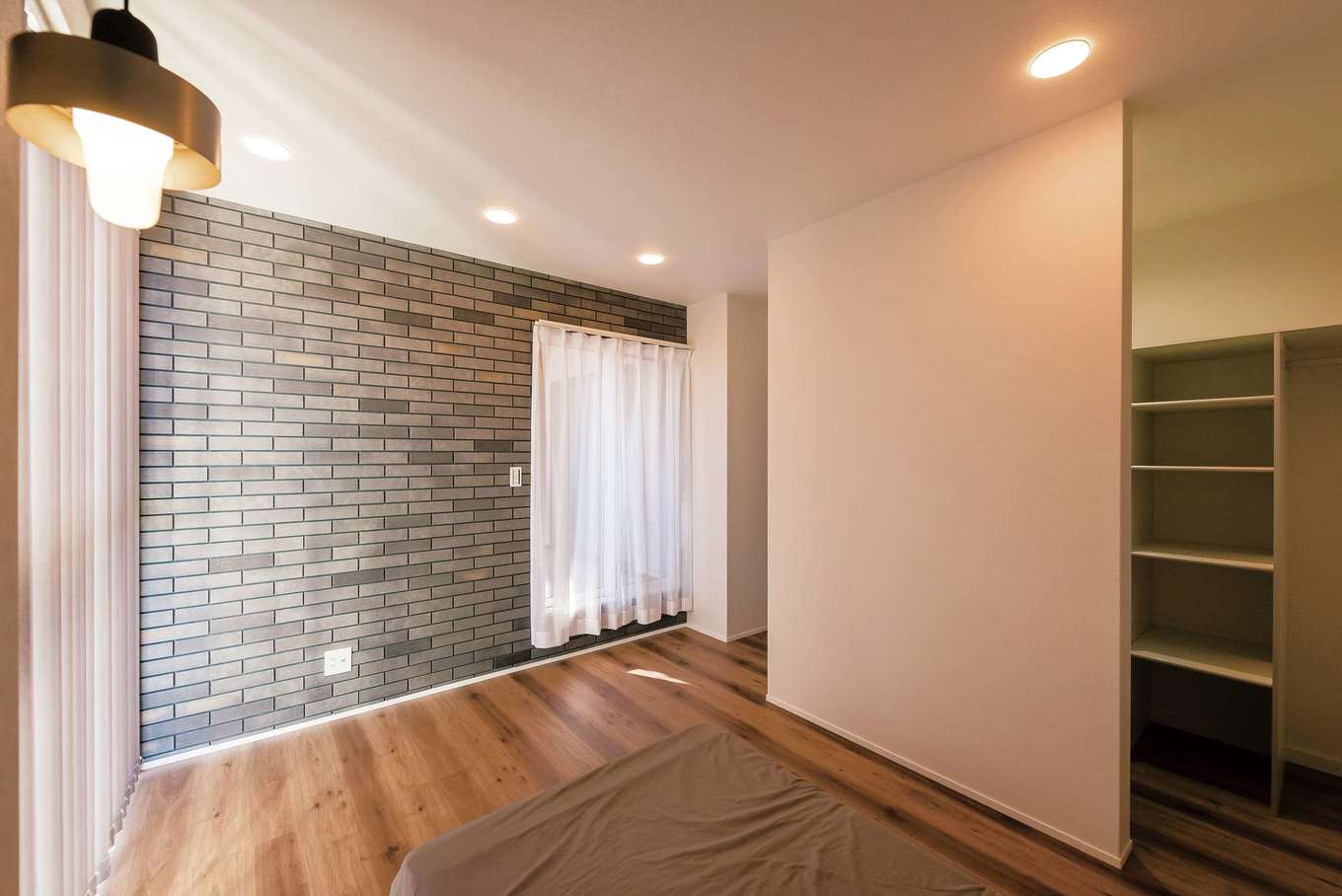 三和建設【省エネ、間取り、スキップフロア】寝室には、外壁、リビングと同じレンガを用いて、家全体のデザインに統一感を
