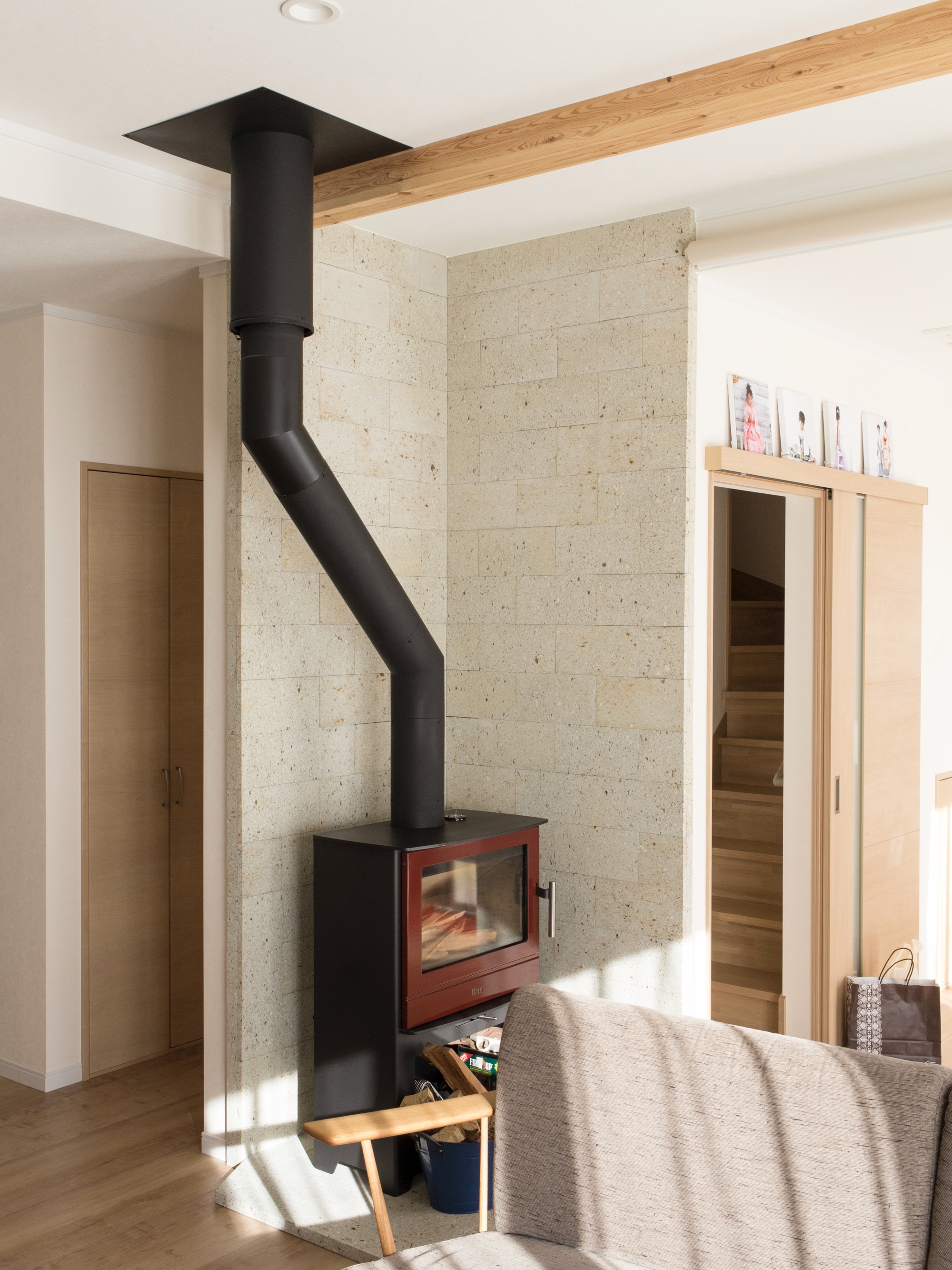 エスホーム｜リビングの一角にある薪ストーブ。地元特産の大谷石は、耐火レンガに比べ、明るくすっきりとした印象になるのでリビングの統一感が出る。優れた耐火性はもちろん、消臭性や吸湿効果もあり、コストもそんなに高くない。