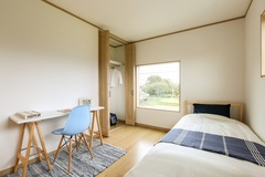 明るい日の光が差し込む子ども部屋。シンプルな机とベッドが設置され、勉強と休息が快適にできる空間である。
