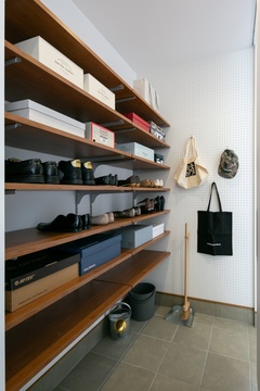 可動棚を豊富に備えた、大容量のシューズクローク。一面の壁が有孔ボードになり、帽子やバッグを掛けて収納できるのが便利。モノのありかが一目瞭然なのもうれしい