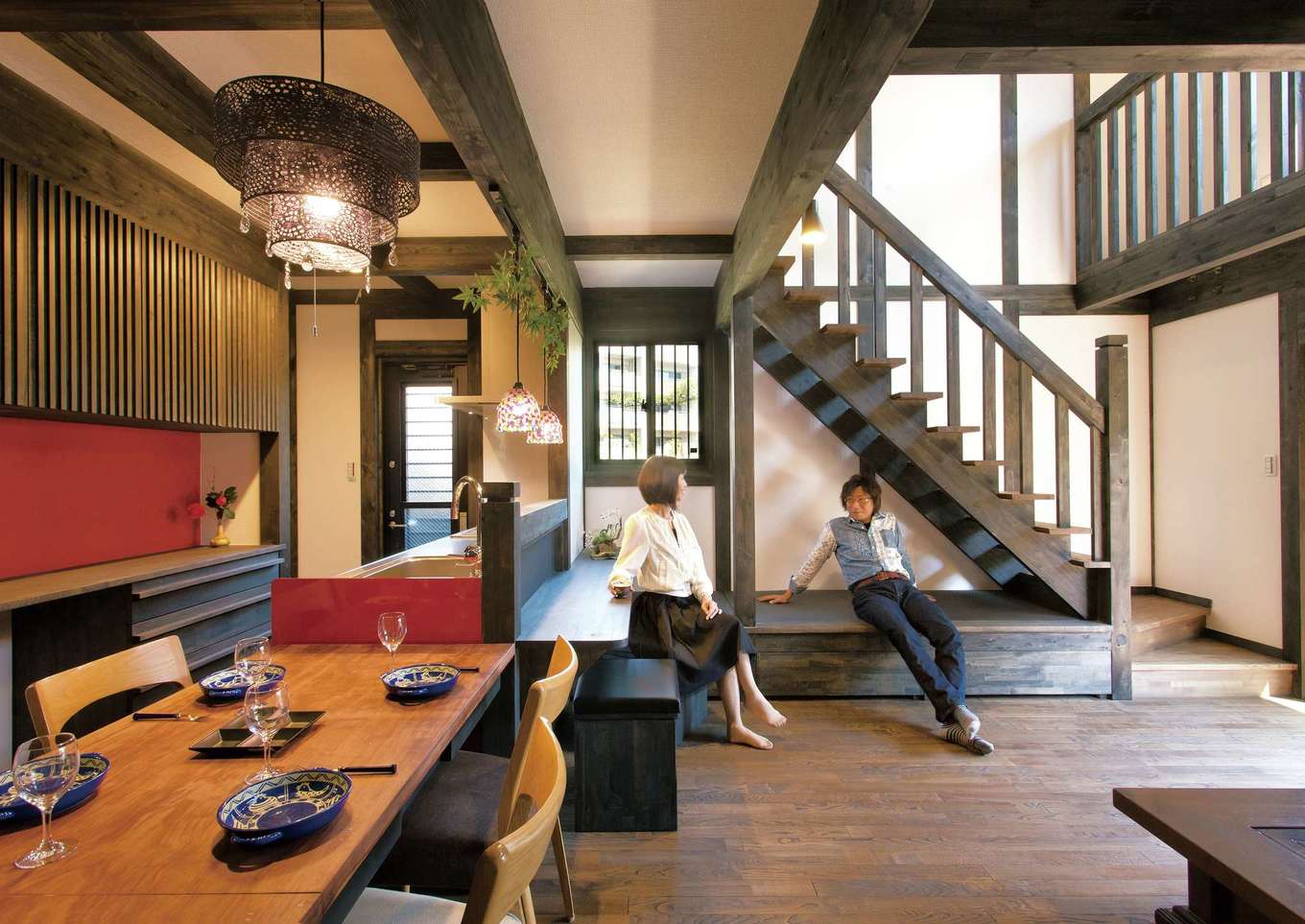 サイエンスホーム【1000万円台、趣味、自然素材】黒い柱と梁に白い壁が映える真壁づくりの大空間。 赤いキッチンとニッチが差し色になっている。階段下に畳コーナーを設け、家族やゲストとのコミュニケーションもスムーズ