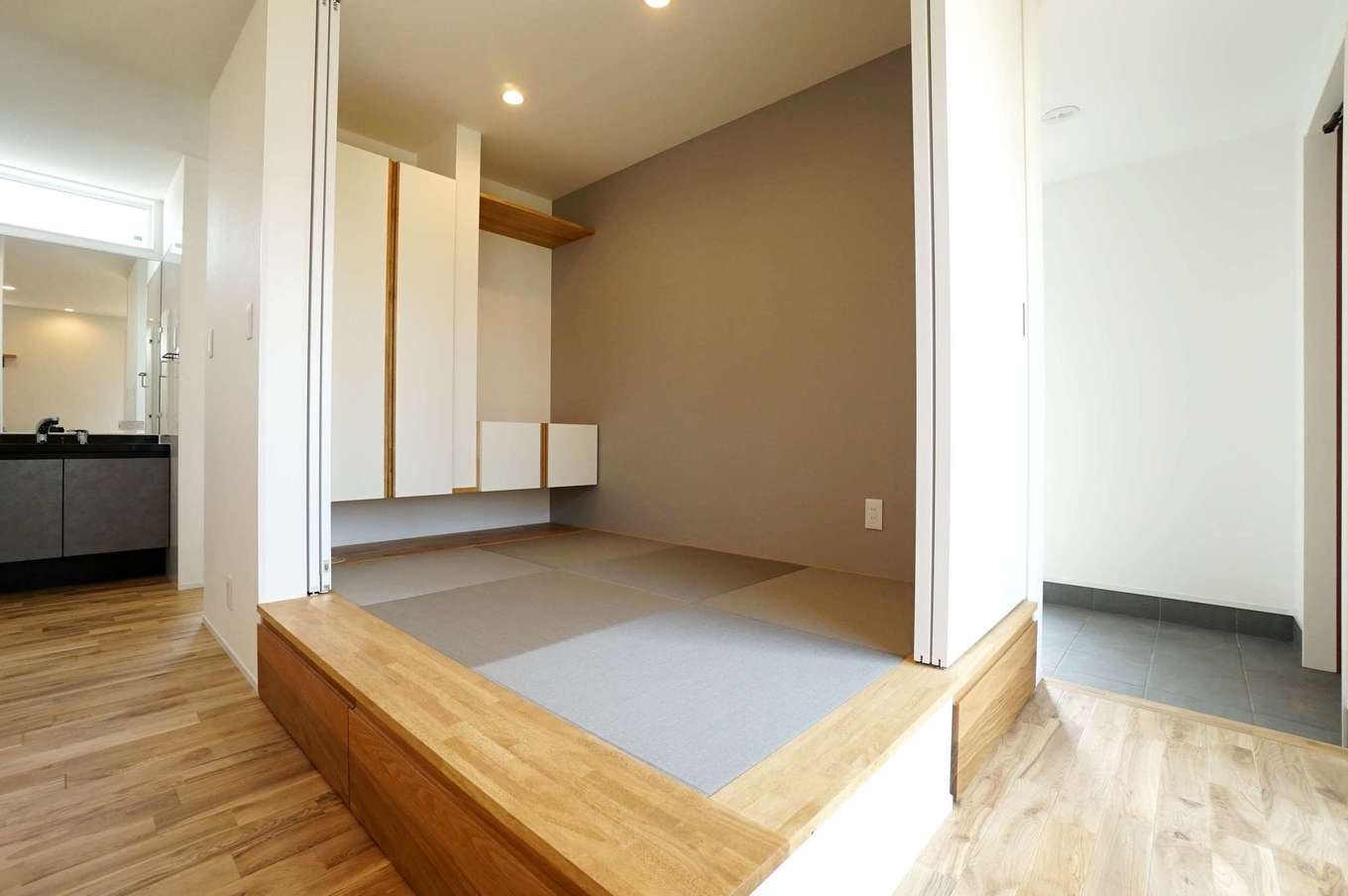 RIKYU 一級建築士事務所【二世帯住宅、間取り、建築家】リビング内にある小上がりの畳コーナー。間仕切りもできるので、ゲストの寝室にもなる。畳の下部は収納